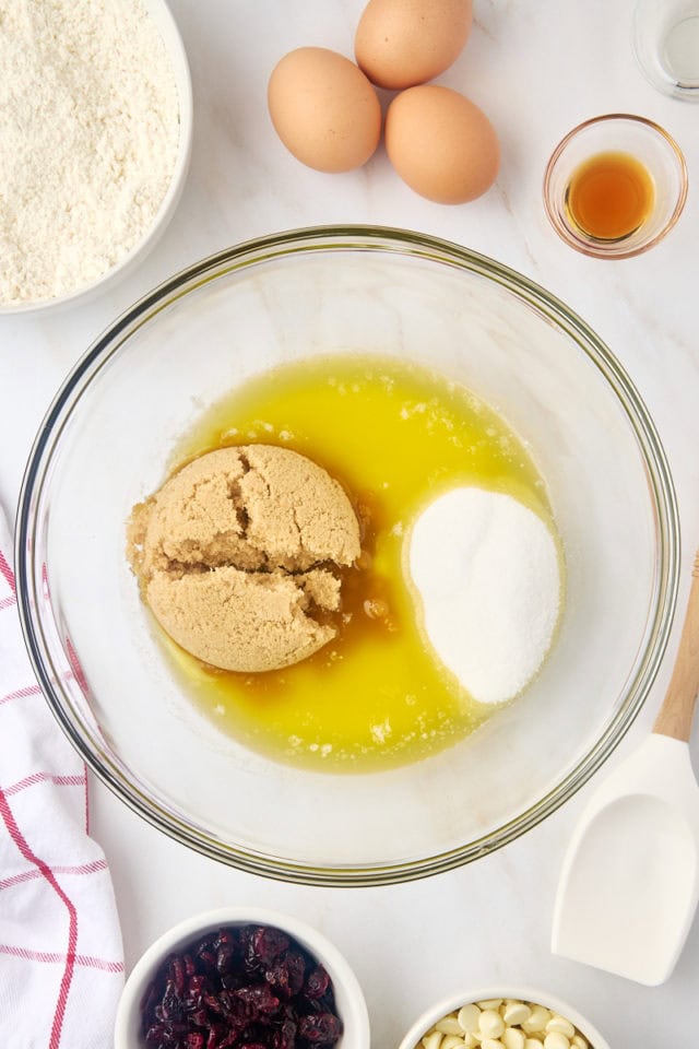 overhead view of melted butter, brown sugar, and sugar in a mixing bowl