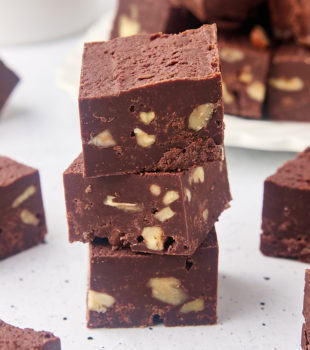 stack of three pieces of fudge surrounded by more fudge