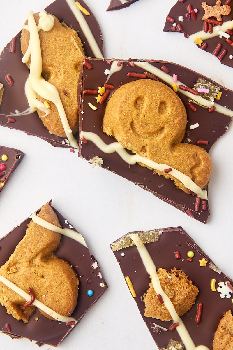 several pieces of gingerbread bark scattered on a marble countertop