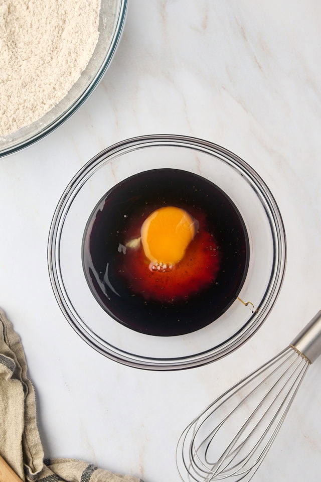 overhead view of molasses, honey, and egg in a mixing bowl