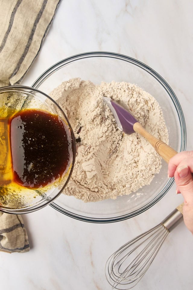 overhead view of wet ingredients being added to dry ingredients for Pfeffernüsse cookies