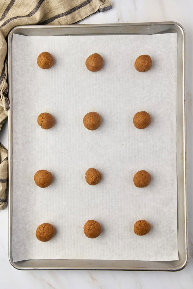 overhead view of Pfeffernüsse cookie dough rolled into balls on a baking sheet