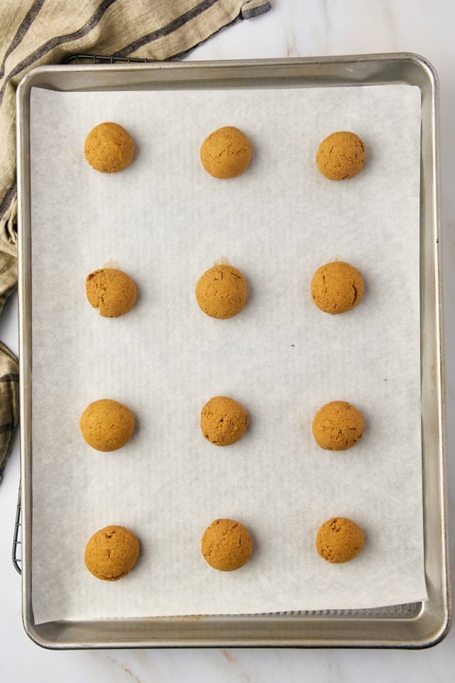 overhead view of freshly baked Pfeffernüsse cookies on a baking sheet