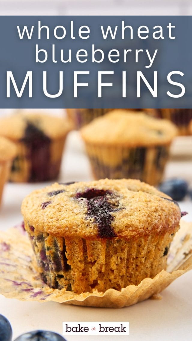 close-up view of a whole wheat blueberry muffin with more muffins in the background; text overlay "whole wheat blueberry muffins"