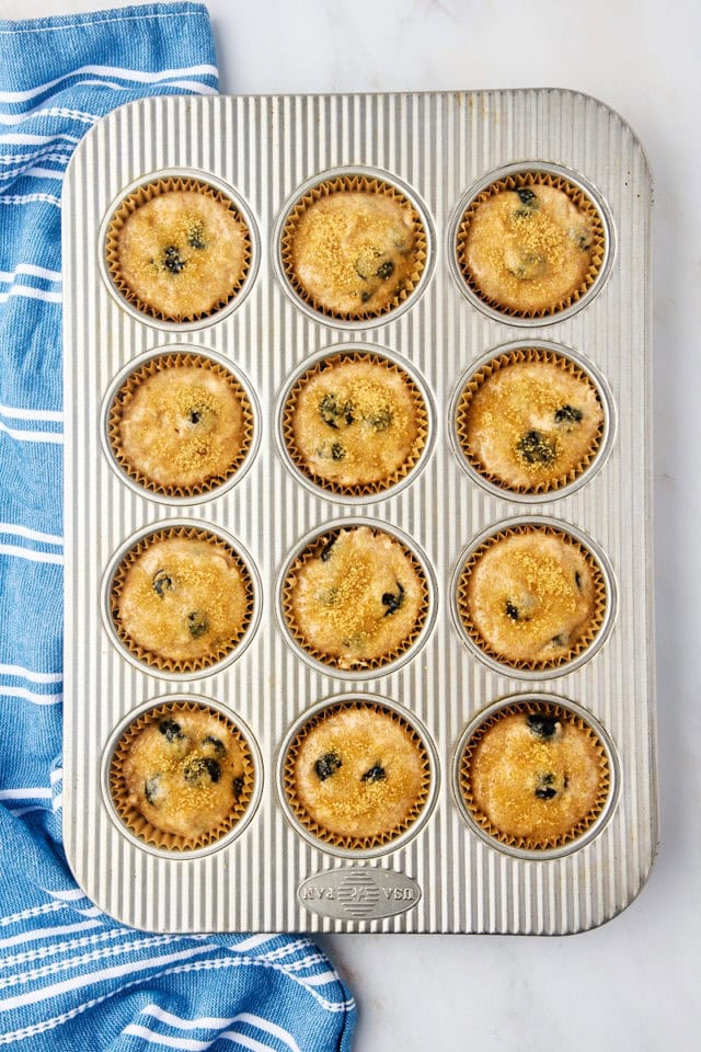 overhead view of portioned whole wheat blueberry muffin batter topped with turbinado sugar