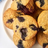 overhead view of whole wheat blueberry muffins on a white plate