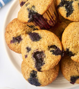 overhead view of whole wheat blueberry muffins on a white plate