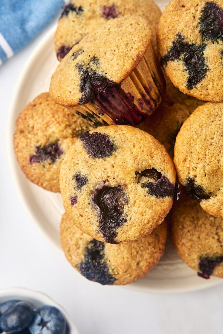 overhead view of whole wheat blueberry muffins on a white plate