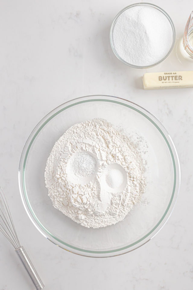 overhead view of flour, baking powder, and salt in a glass mixing bowl