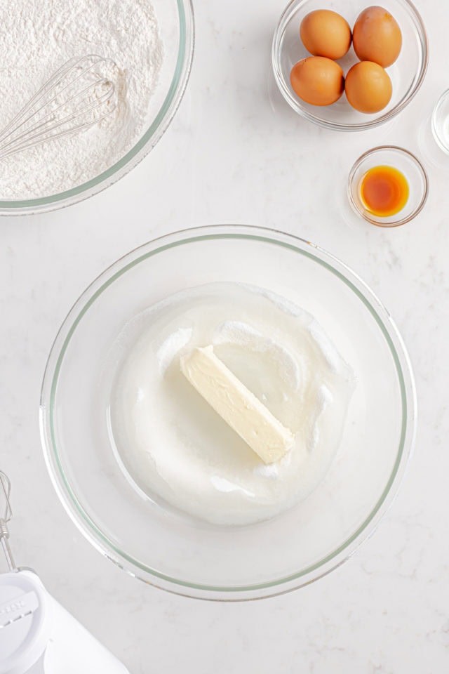 overhead view of butter, oil, and sugar in a glass mixing bowl