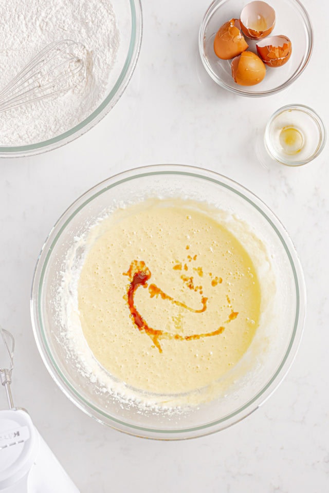 overhead view of vanilla and lemon extracts added to cake batter