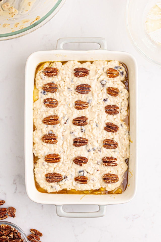 overhead view of unbaked caramel apple pear cobbler topped with pecan halves