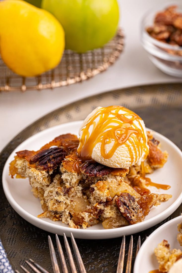 a serving of caramel apple pear cobbler topped with vanilla ice cream and caramel sauce