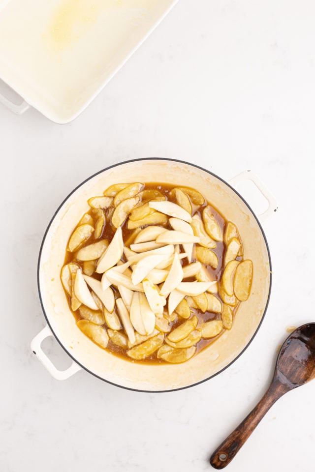 overhead view of sliced pears added to cooked apple mixture