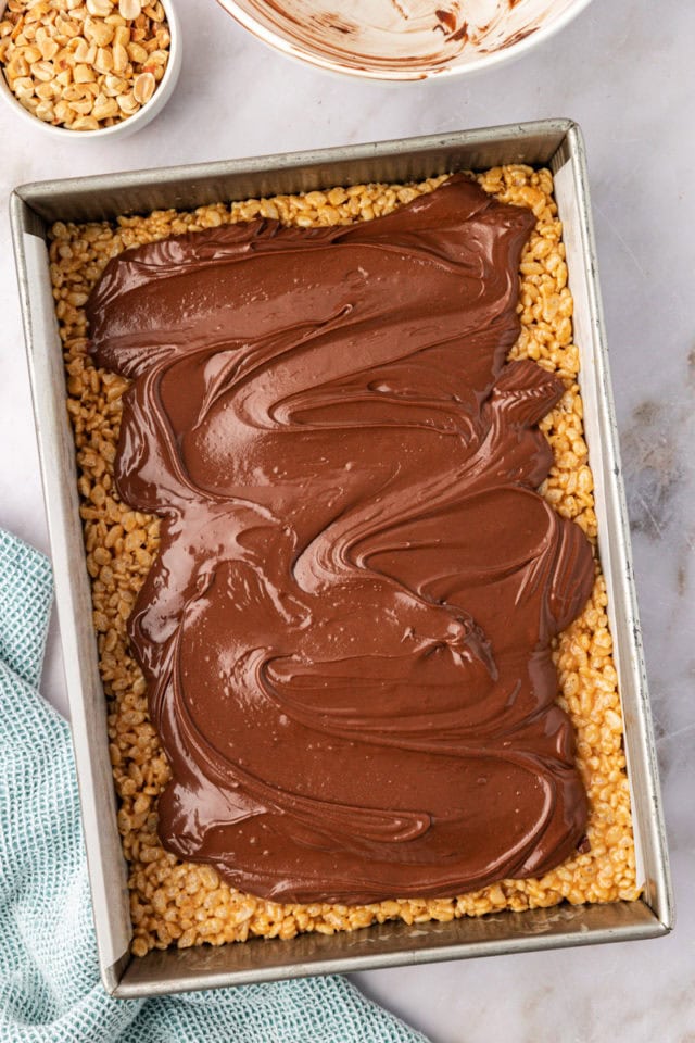 overhead view of melted chocolate and peanut butter chips partially spread over rice crispy treats