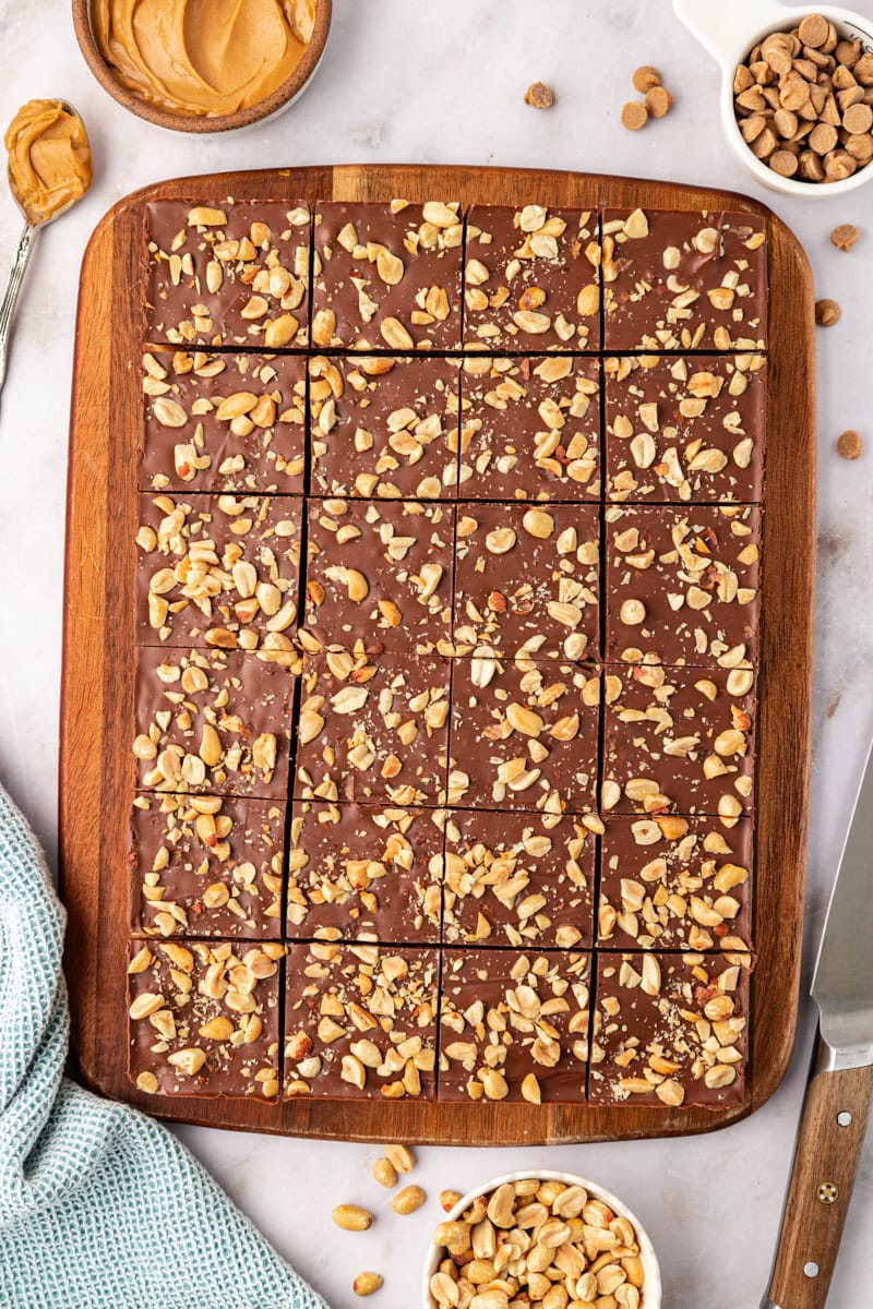 overhead view of sliced chocolate peanut butter rice crispy treats on a wooden cutting board