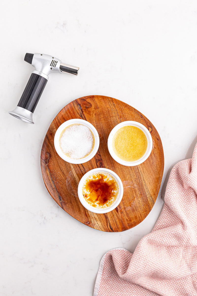 overhead view of three ramekins of crème brûlée—one with caramelized sugar, another with just sugar, and another plain