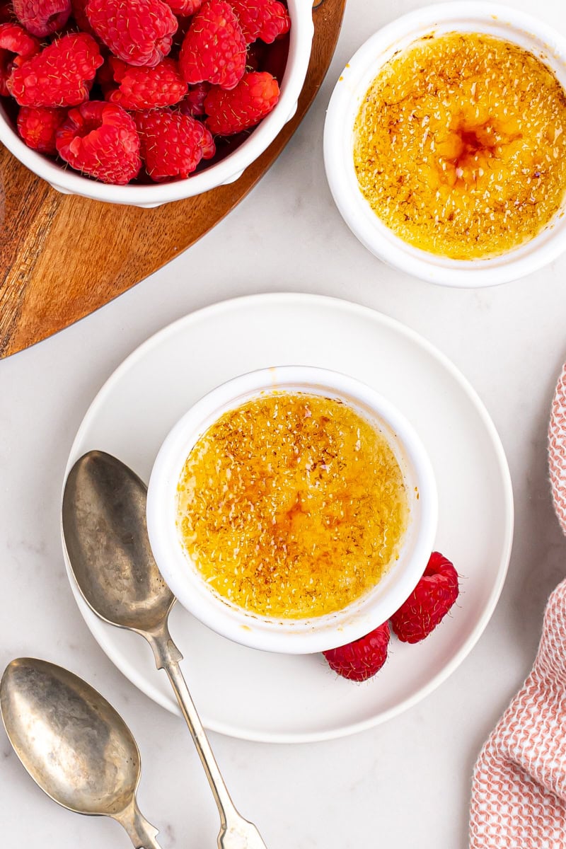 overhead view of crème brûlée in a ramekin placed on a white plate