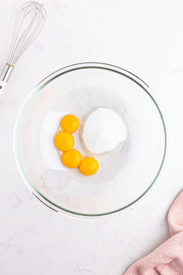 overhead view of egg yolks and sugar in a mixing bowl