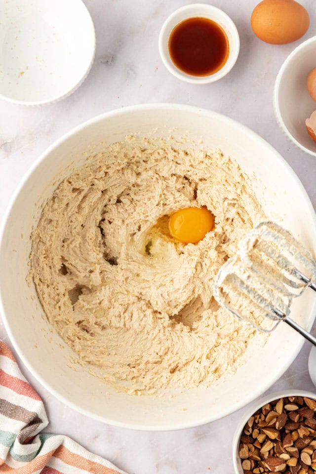 overhead view of egg added to creamed butter and sugar