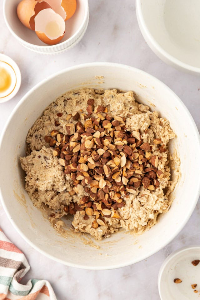 overhead view of chopped nuts added to oatmeal cookie dough