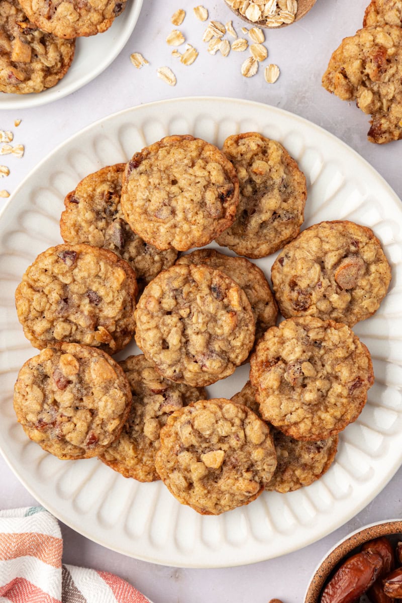 overhead view of several oatmeal date cookies on a white plate