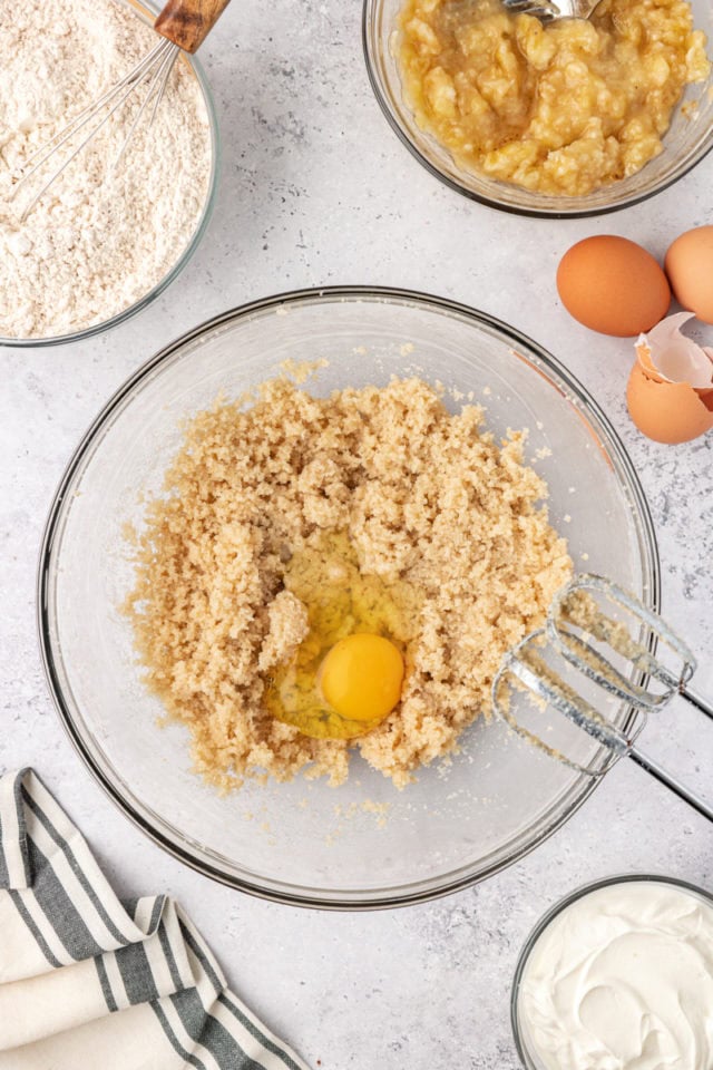 overhead view of egg added to creamed butter and sugar