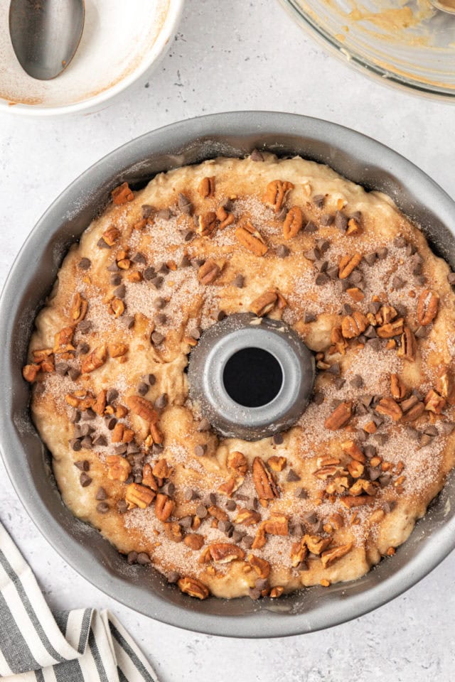 overhead view of remaining chocolate and nut mixture on top of banana coffee cake batter in a Bundt pan