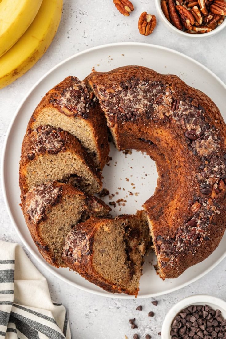 partially sliced banana coffee cake on a white cake plate