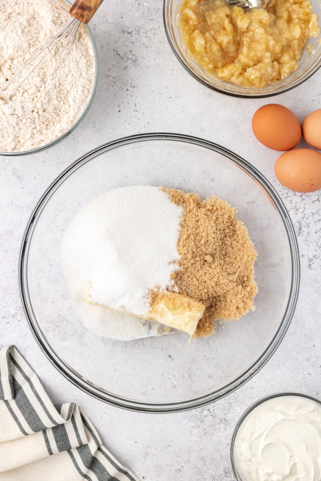 overhead view of butter, sugar, and brown sugar in a glass mixing bowl