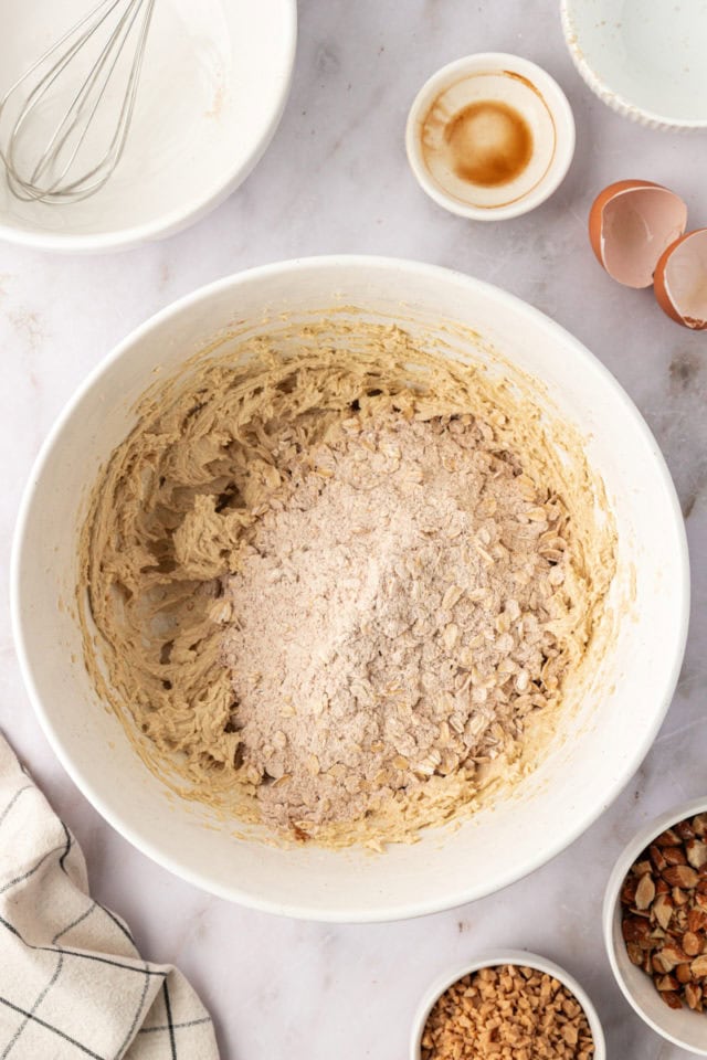 overhead view of dry ingredients added to wet ingredients for toffee almond oatmeal cookies