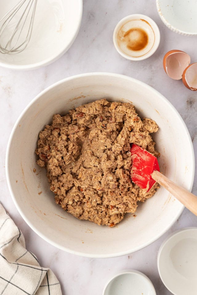 overhead view of toffee almond oatmeal cookie dough in a white mixing bowl