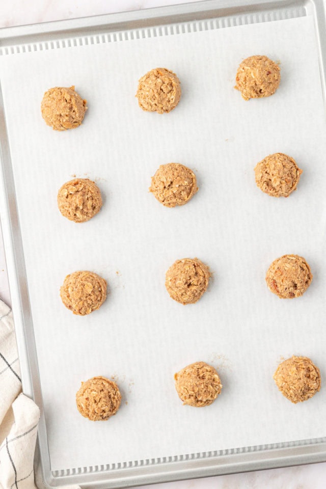 overhead view of scooped toffee almond oatmeal cookie dough on a baking sheet