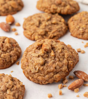 several toffee almond oatmeal cookies on a white countertop