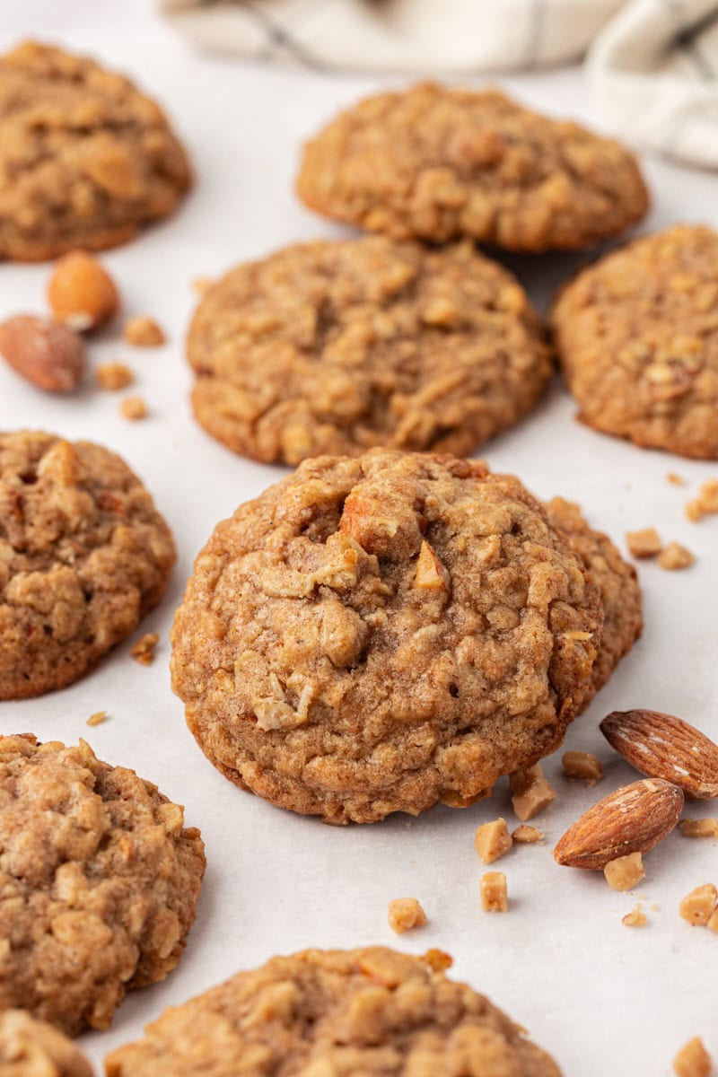 several toffee almond oatmeal cookies on a white countertop