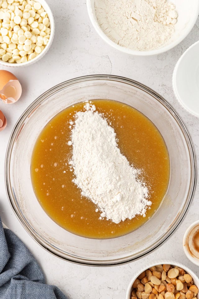 overhead view of dry ingredients added to wet ingredients for white chocolate blondies