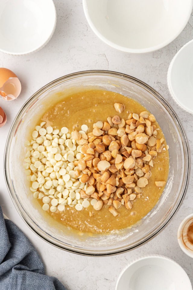 overhead view of white chocolate chips and macadamia nuts added to blondie batter