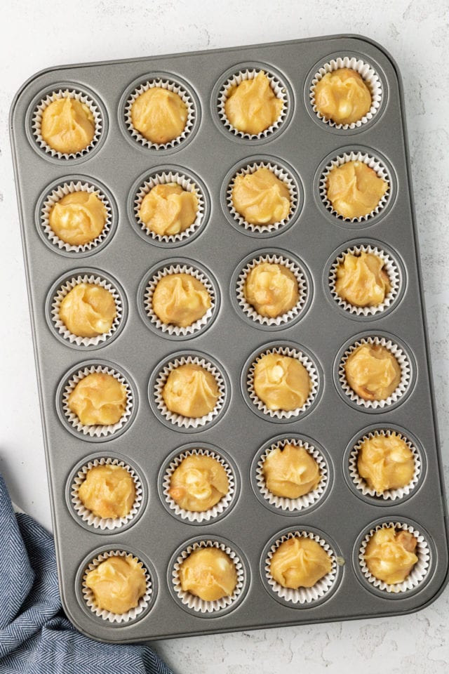 overhead view of white chocolate blondie batter portioned in a mini muffin pan