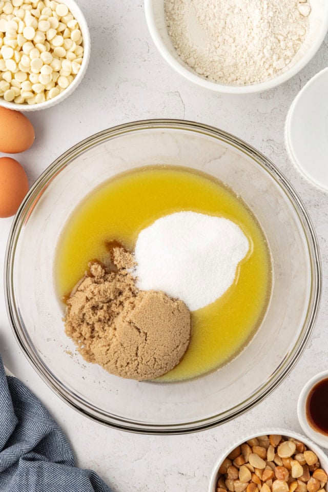 overhead view of sugar and brown sugar added to melted butter and white chocolate