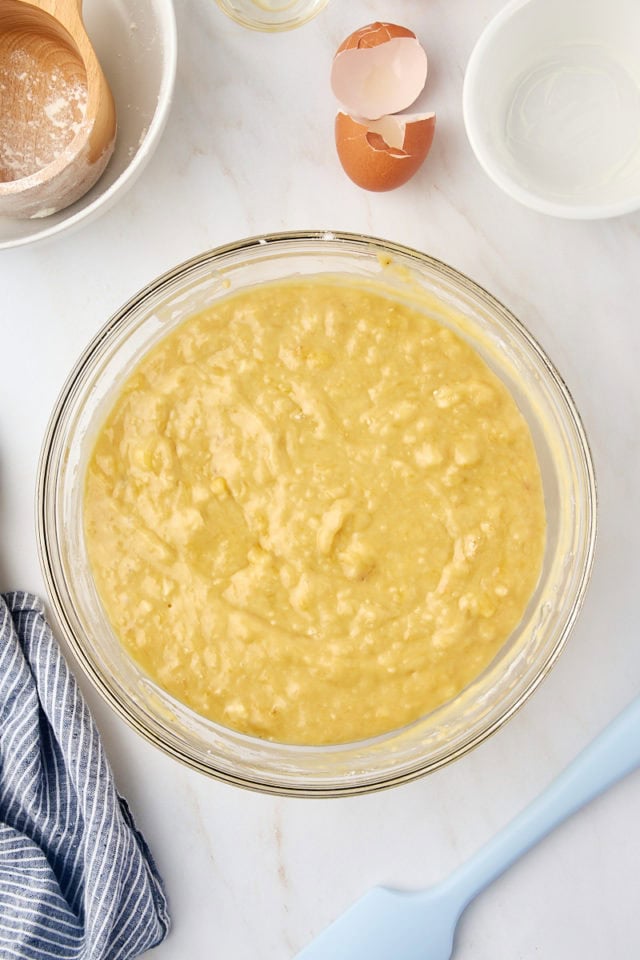 overhead view of banana bread batter in a glass mixing bowl