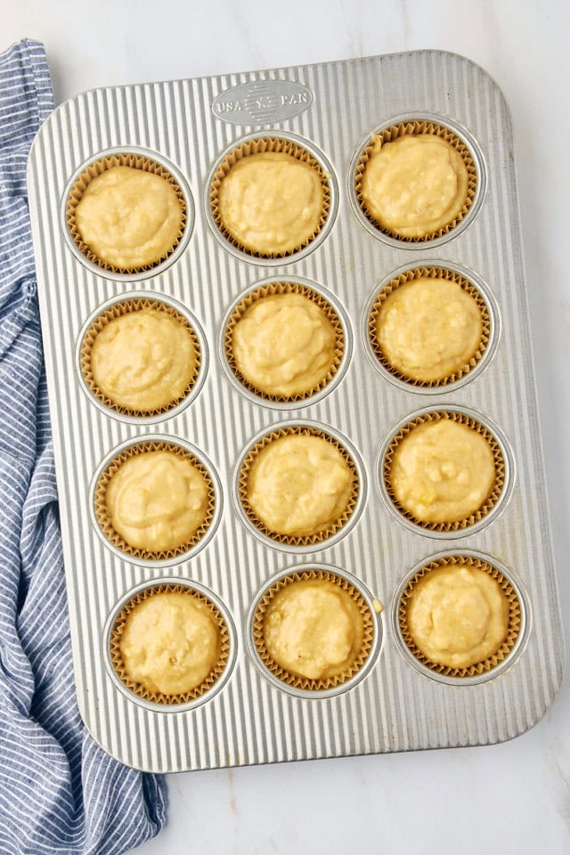 overhead view of banana bread batter portioned in a 12-cup muffin pan