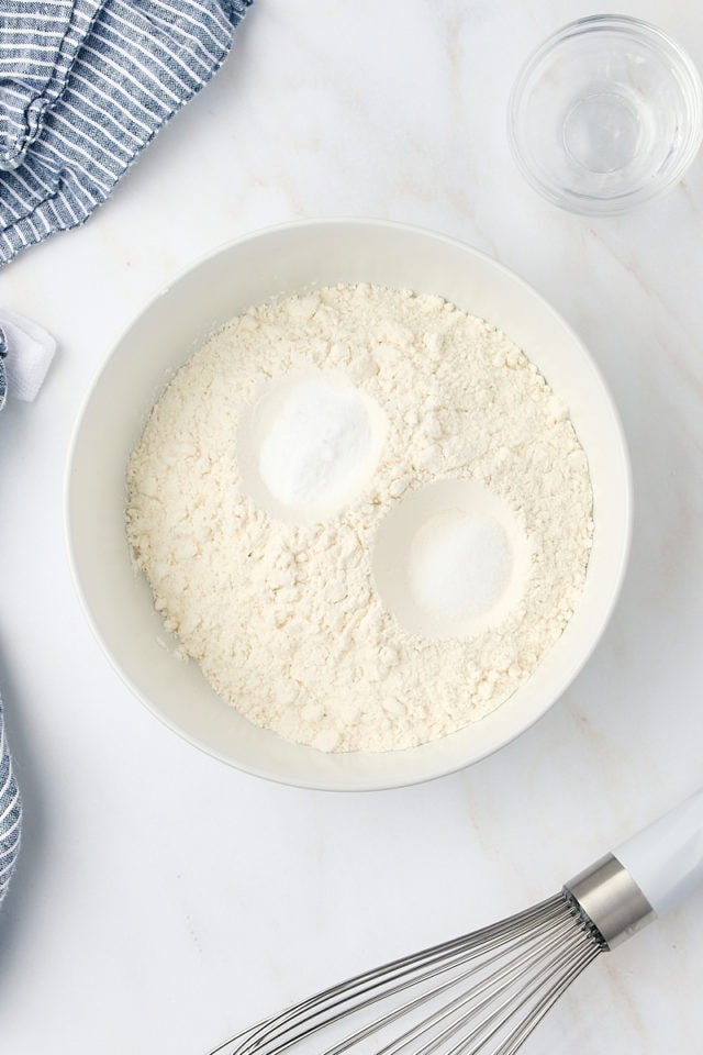 overhead view of flour, baking soda, and salt in a white bowl