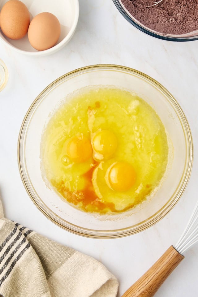 overhead view of eggs and vanilla added to melted butter and sugar mixture