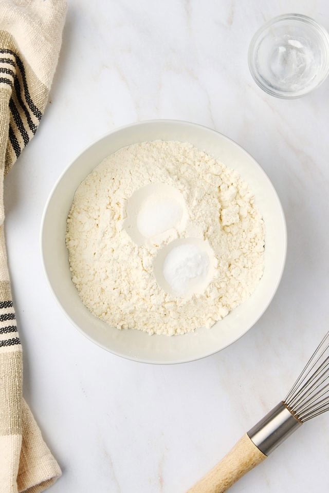 overhead view of flour, baking soda, and salt in a white bowl