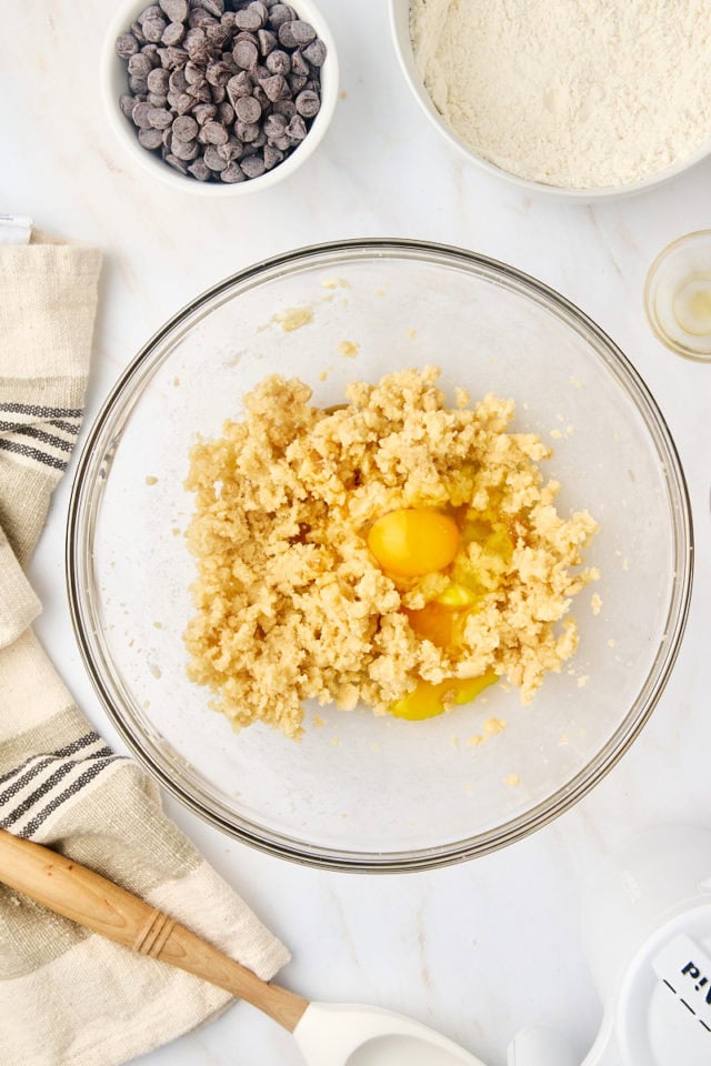 overhead view of egg added to creamed butter and sugar