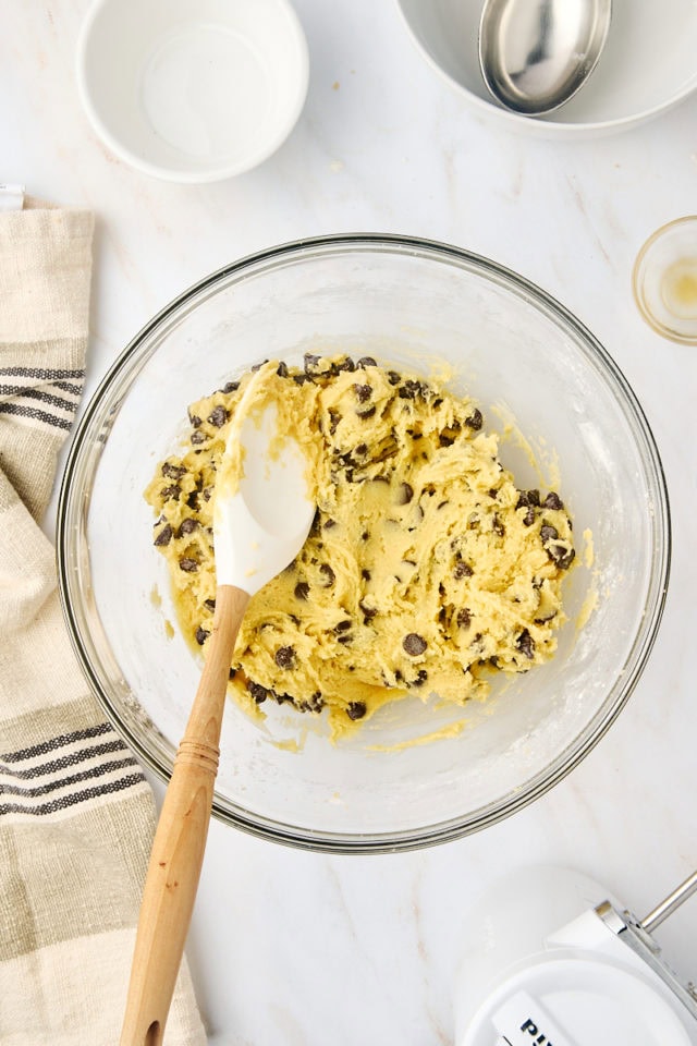 overhead view of chocolate chip cookie dough in a glass mixing bowl