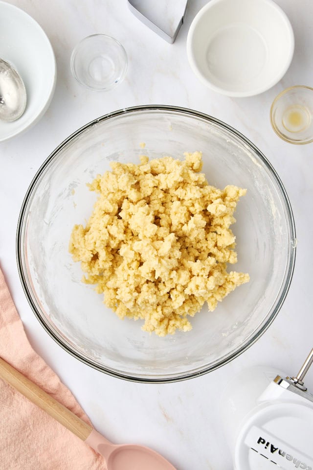 overhead view of mixed shortbread dough in a glass mixing bowl