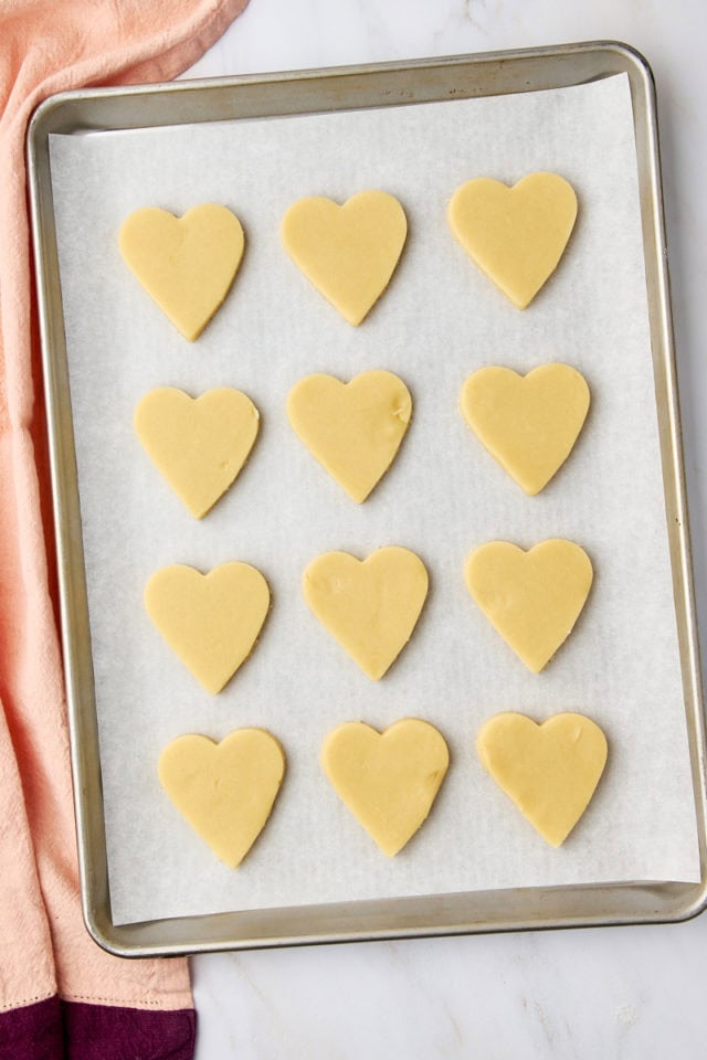 overhead view of chocolate-dipped shortbread cookie dough on a baking sheet ready to go into the oven