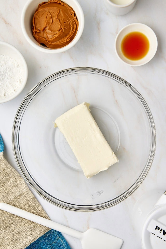 overhead view of cream cheese in a glass mixing bowl