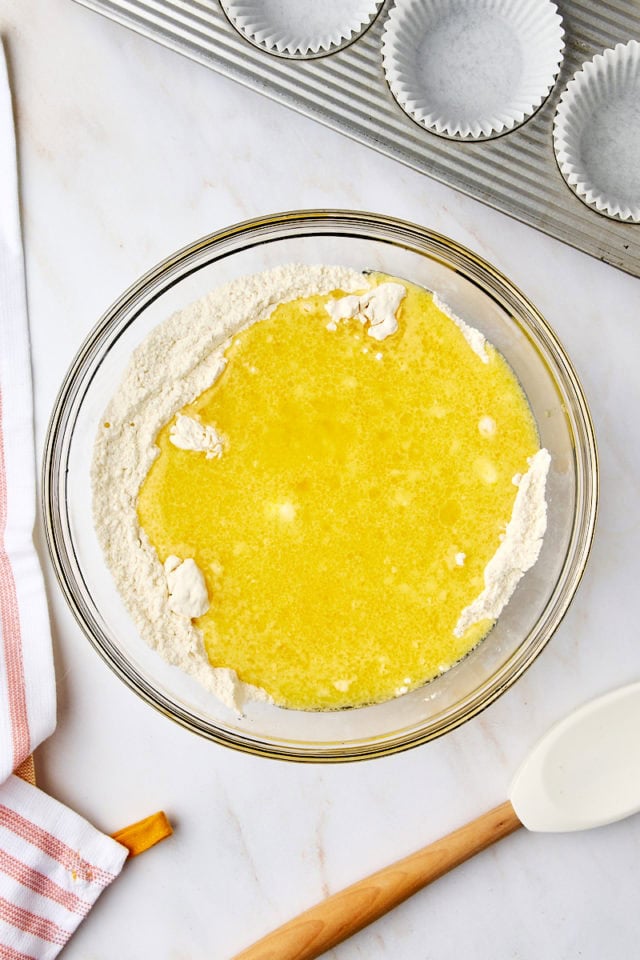 overhead view of wet ingredients added to dry ingredients for orange ricotta muffins